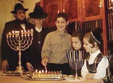 Chaim lights his menorah